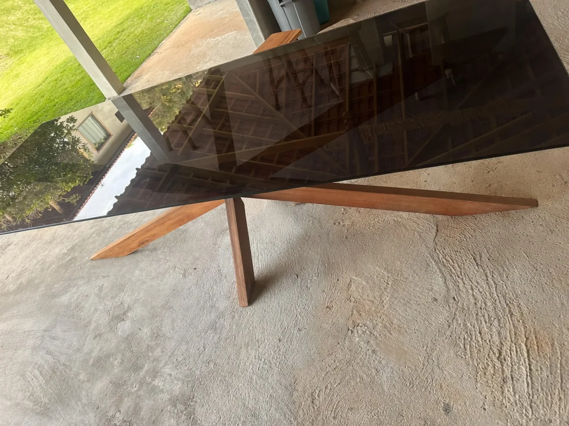 Mesa de madeira com tampo de vidro na varanda